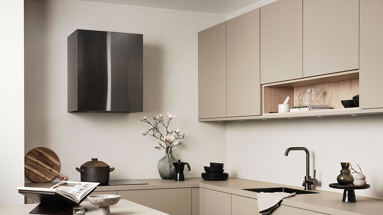 Veggmontert kjøkkenvifte i svart stål i lyst kjøkken.