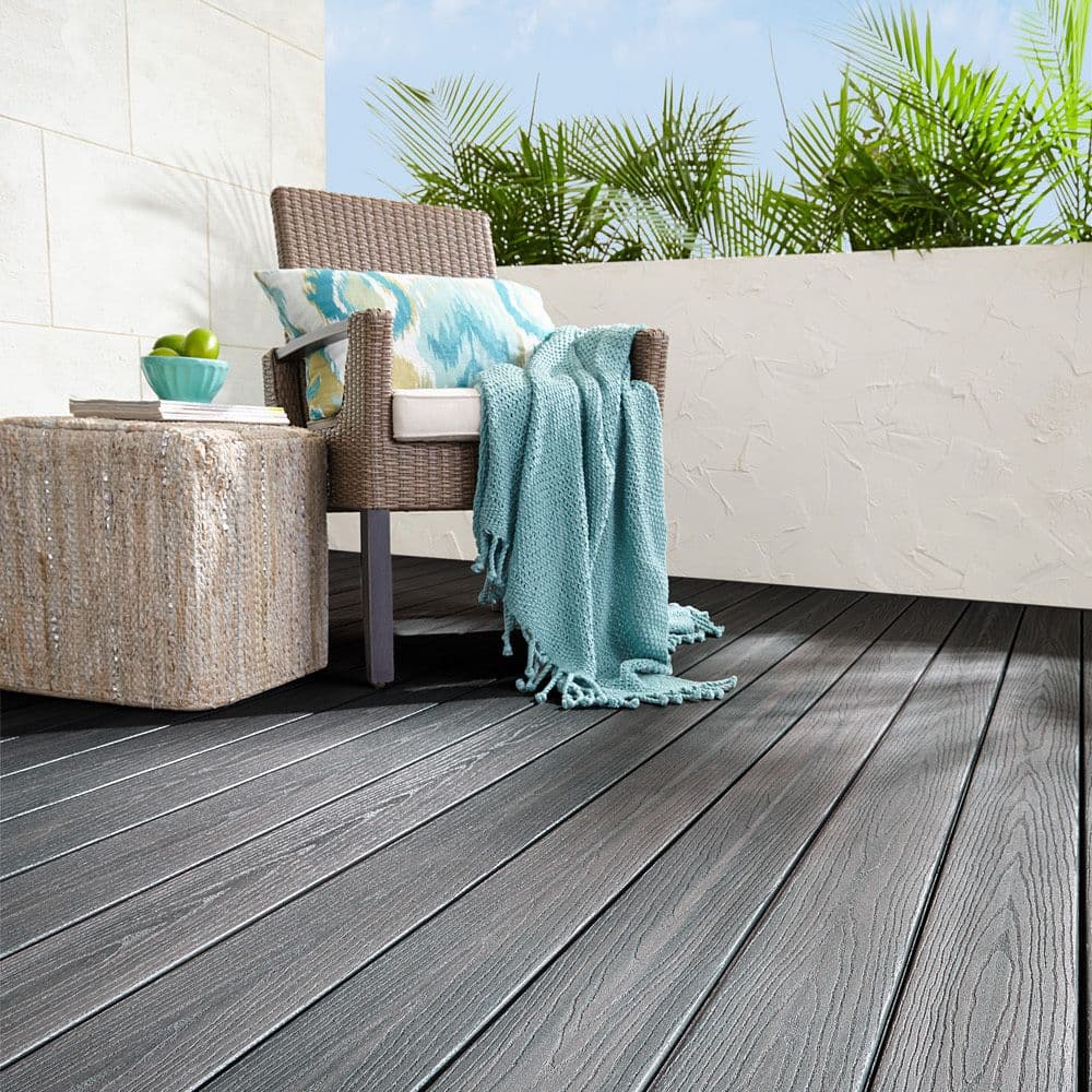 Kurvstol og bord står i et hjørne på en kompositt terrasse bygget med Fiberon Goodlife i fargen Beach Club.