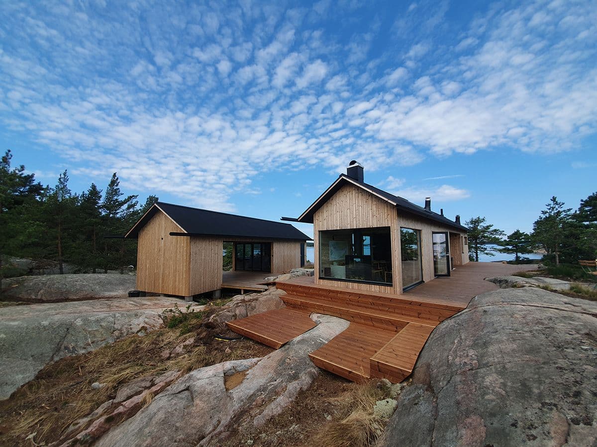 nybygget hytte og anneks ved sjøen, med termofuru som kledning