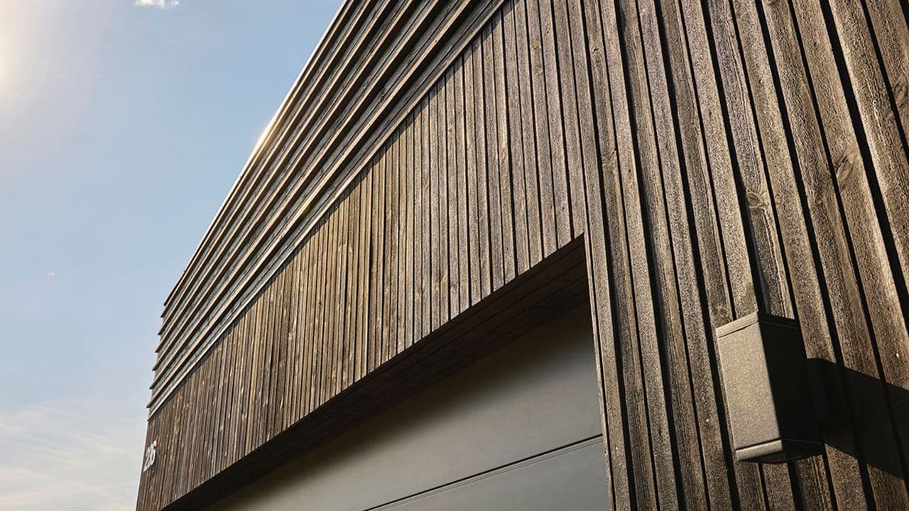 Hus med royalimpregnert kledning og svart garasjeport.