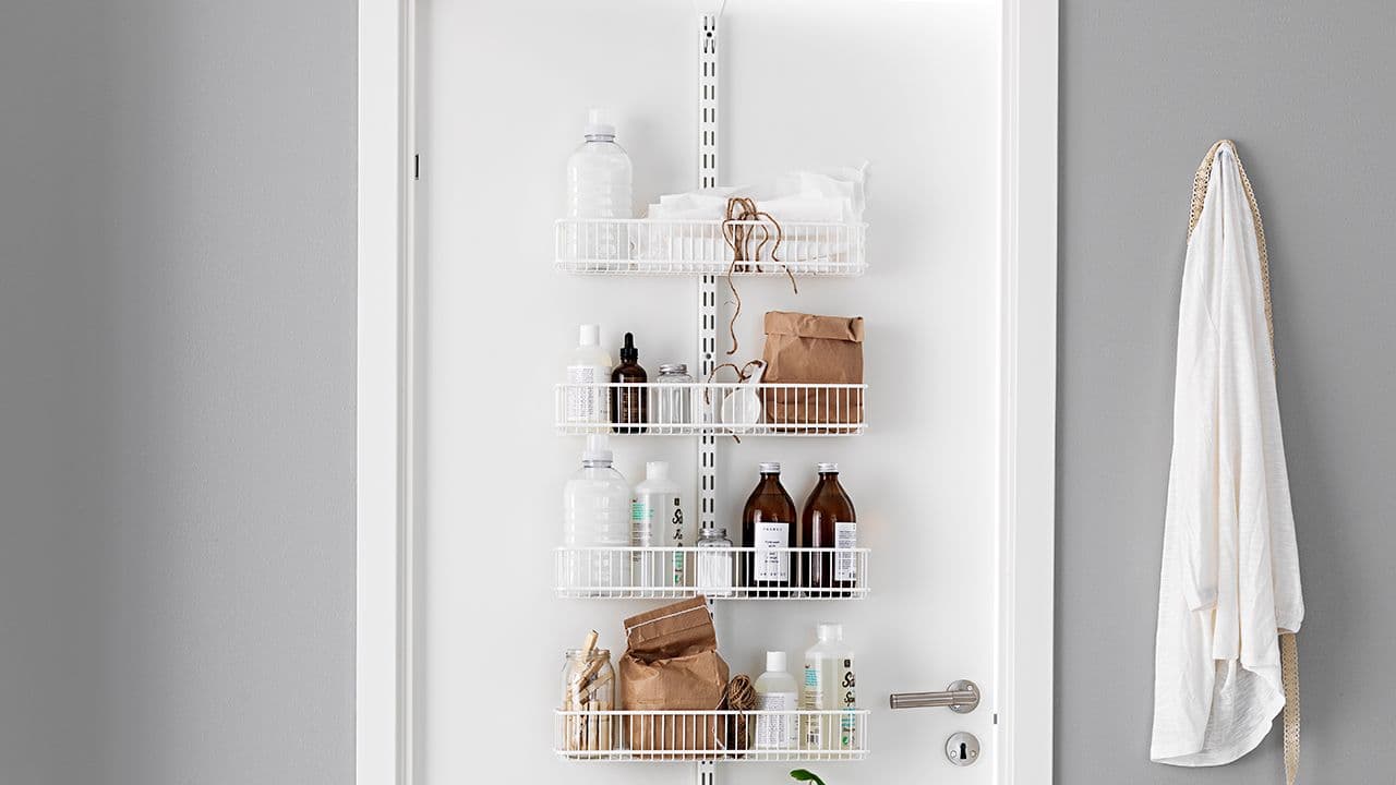 Døroppbevaring med trådkurver i lite hyttebad.