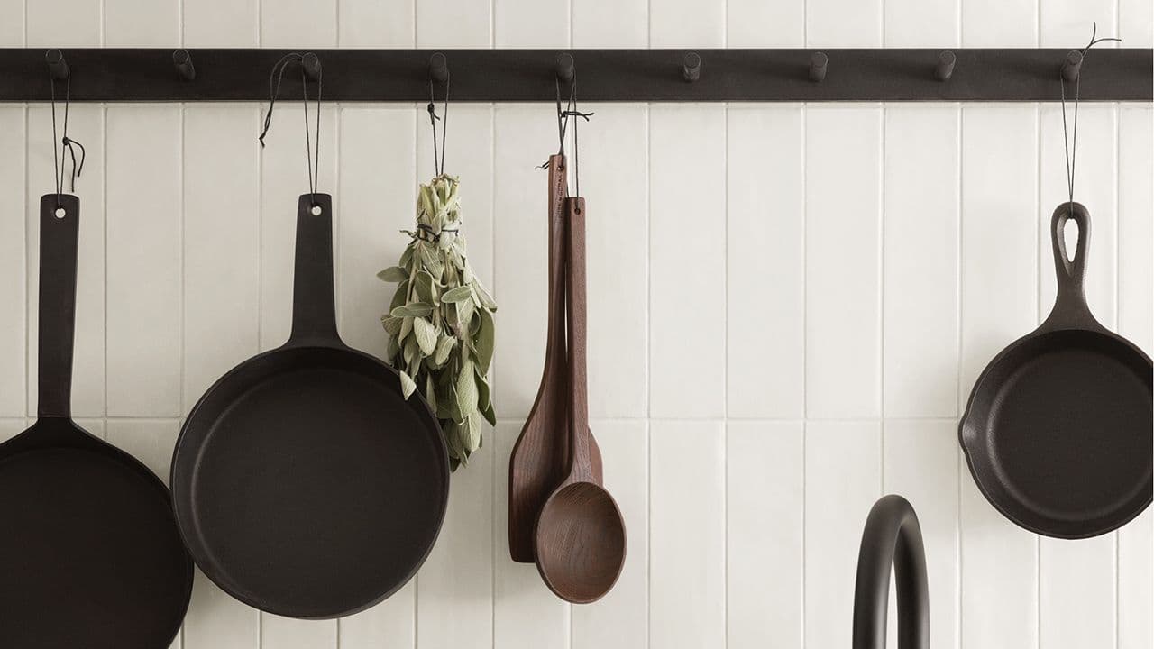 Hyttekjøkken med knaggrekke til oppbevaring av stekepanner og kjøkkenredskaper.