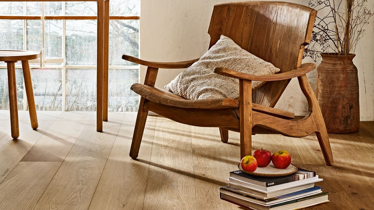 Stue i hytte med lenestol i tre og parkett i eik.