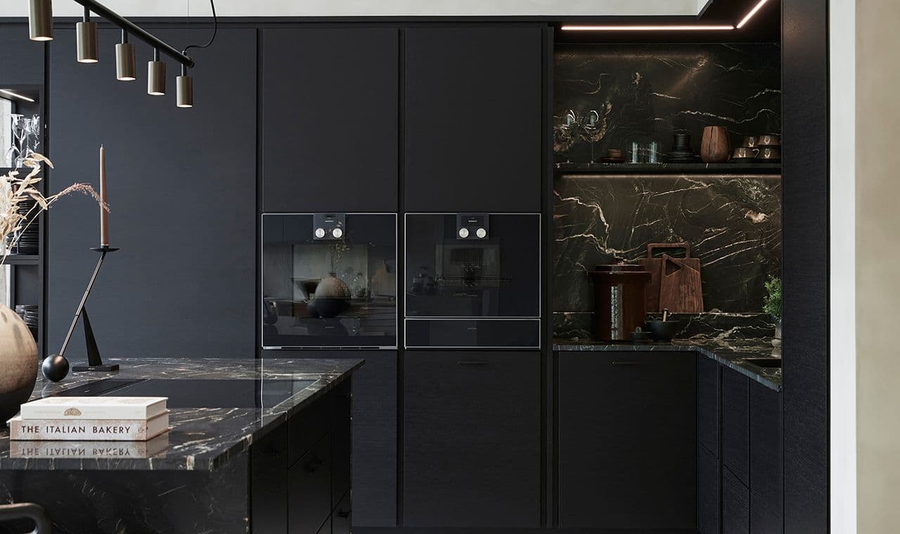 Kjøkken med kjøkkenøy med mørkt steinplate.