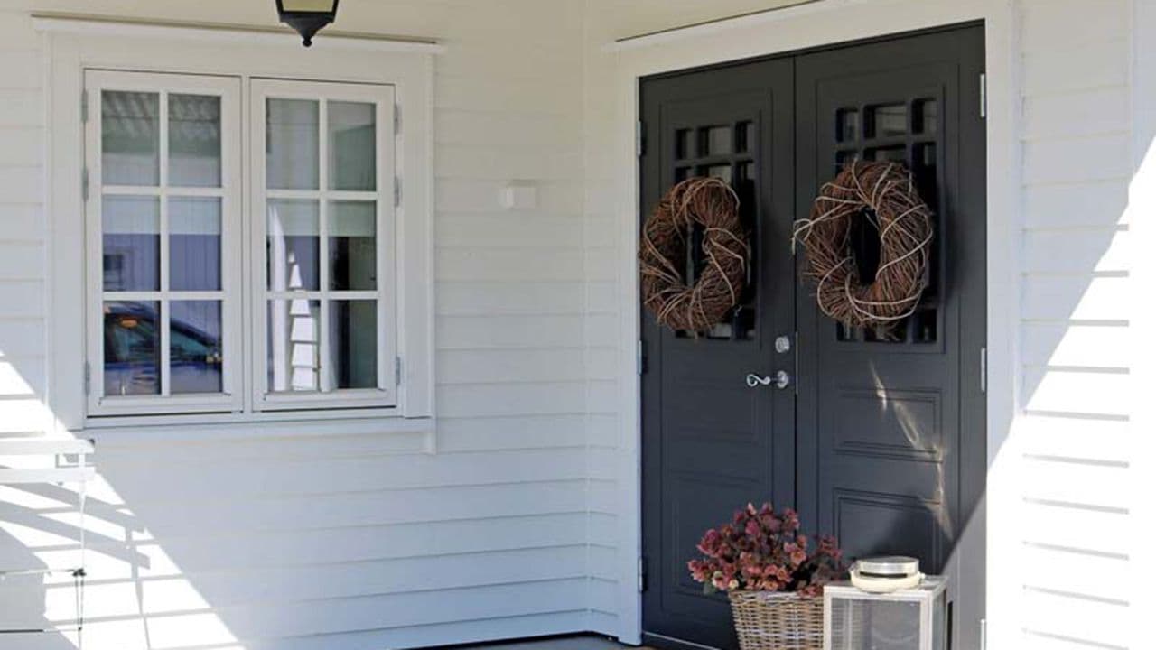 Hvitt hus med tofløyet svart ytterdør fra Harmonie for ytterdør inspirasjon.