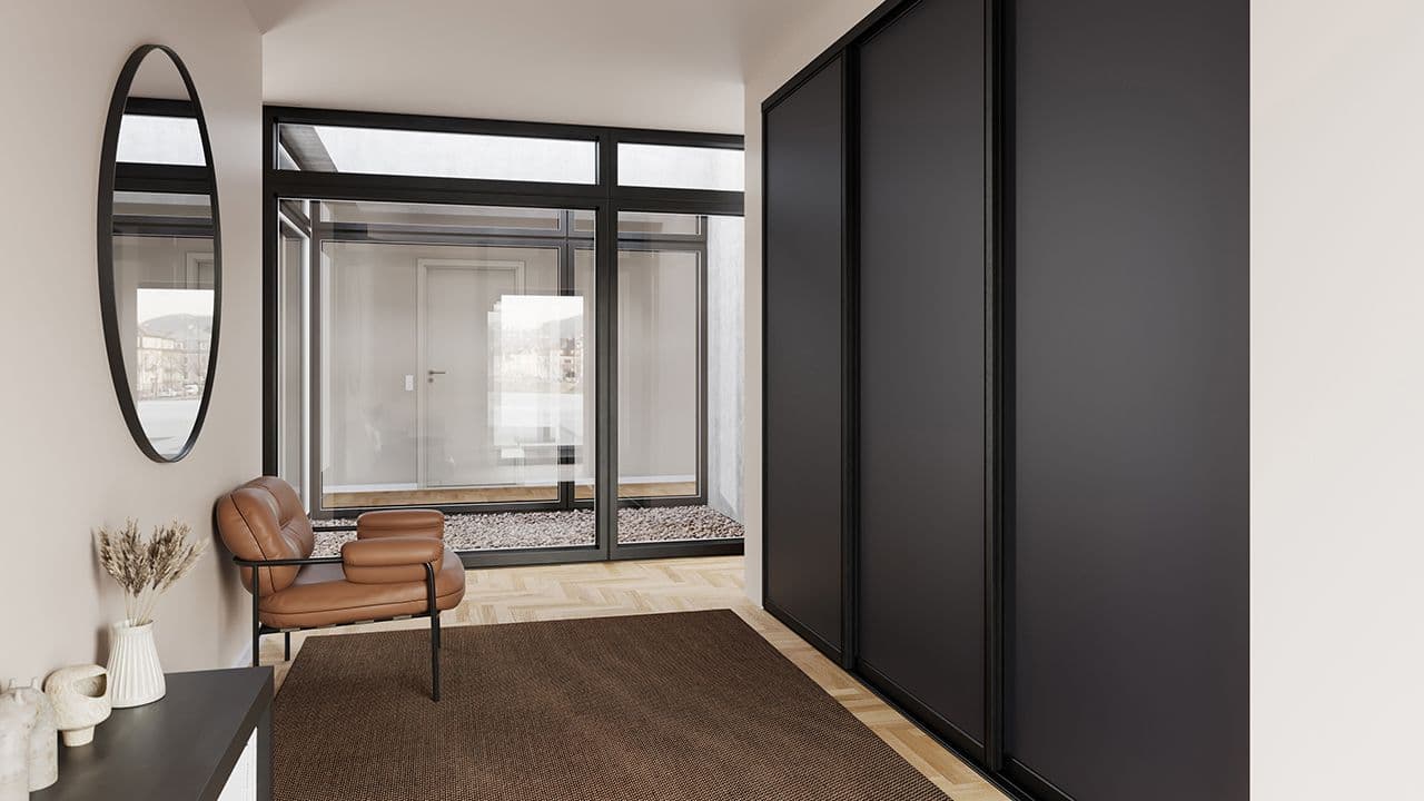 Gang med garderobeskap med skyvedører.