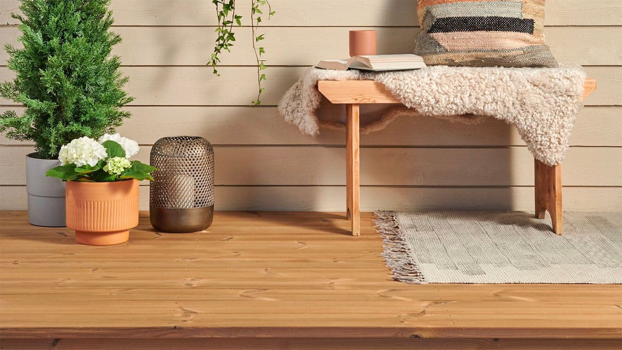 Termofuru terrassebord på terrasse med benk og planter.