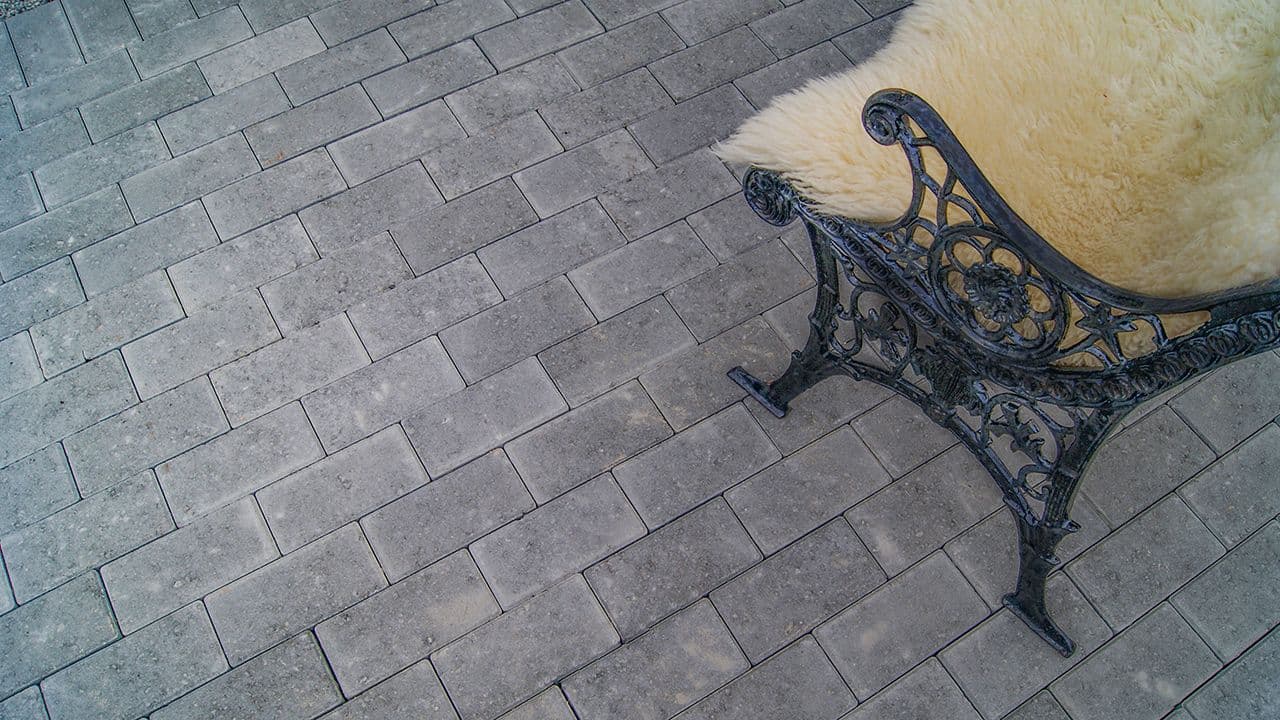 Parkstein belegningsstein og benk i smijern med skinnfell.