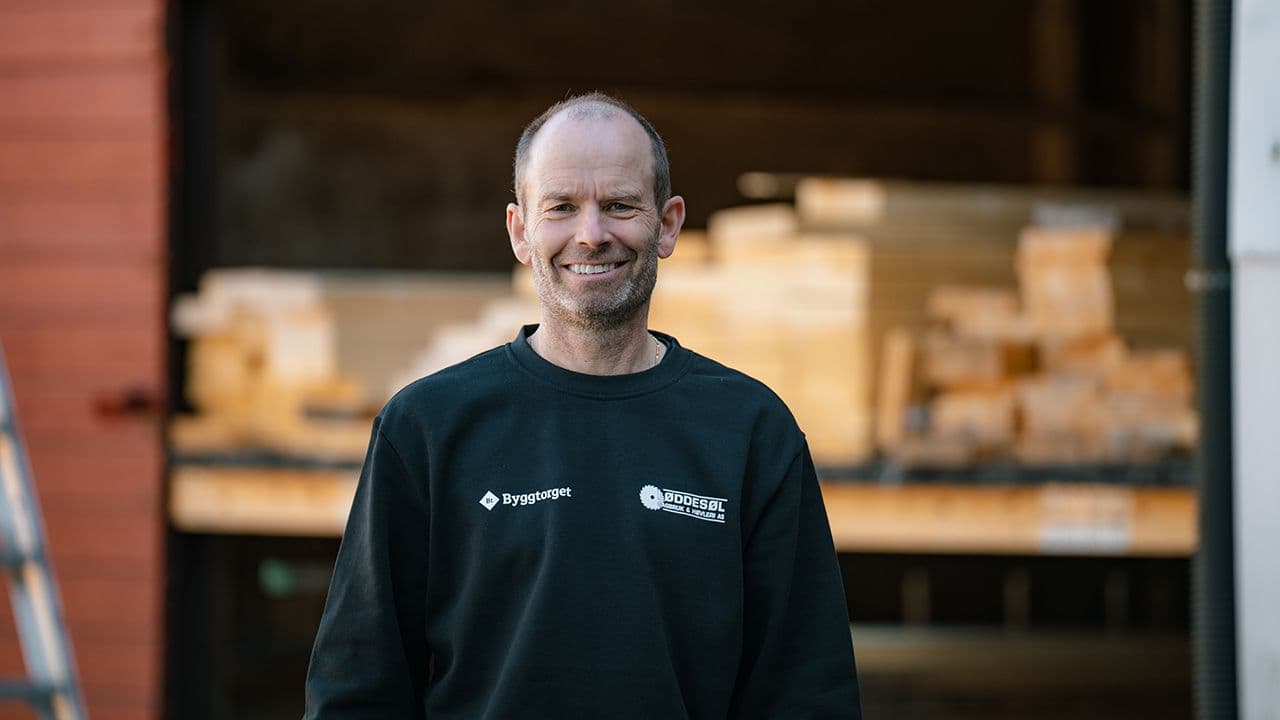 Byggtorget-ansatt foran lager med terrassebord.