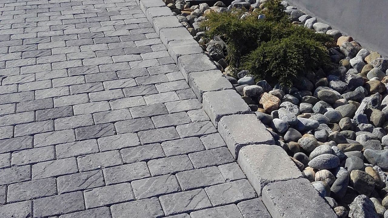 Gangsti med Aas Royal Baron belegningsstein og blomsterbed med kantstein og elvestein.