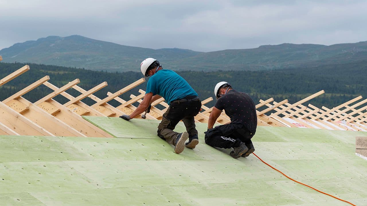Personer som legger konstruksfiner på tak.