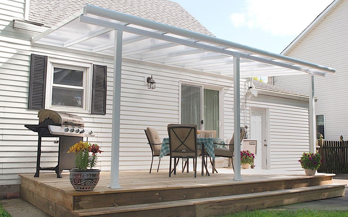 Pergola med tett tak på terrasse med sittegruppe og grill.