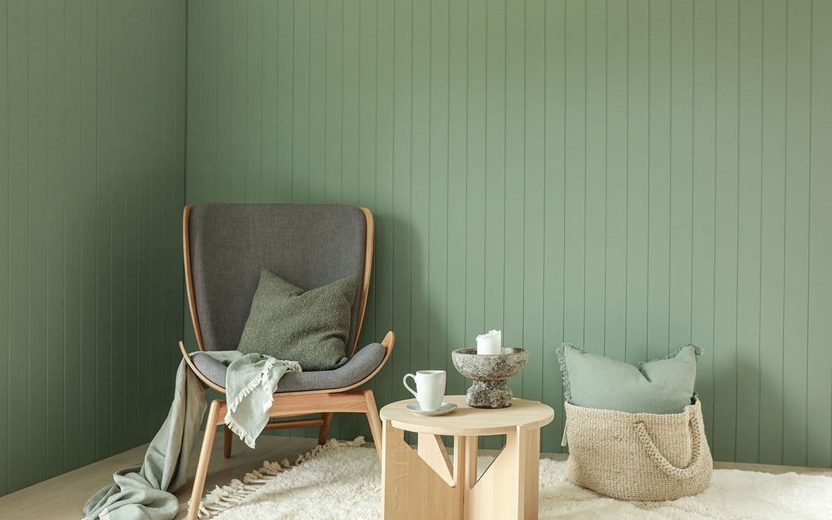 Stue med grå lenestol i hjørne av soverom og panelplater soverom fra smartpanel.