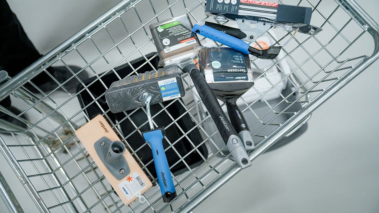 Handlekurv med det utstyret du trenger for å beise terrassen.