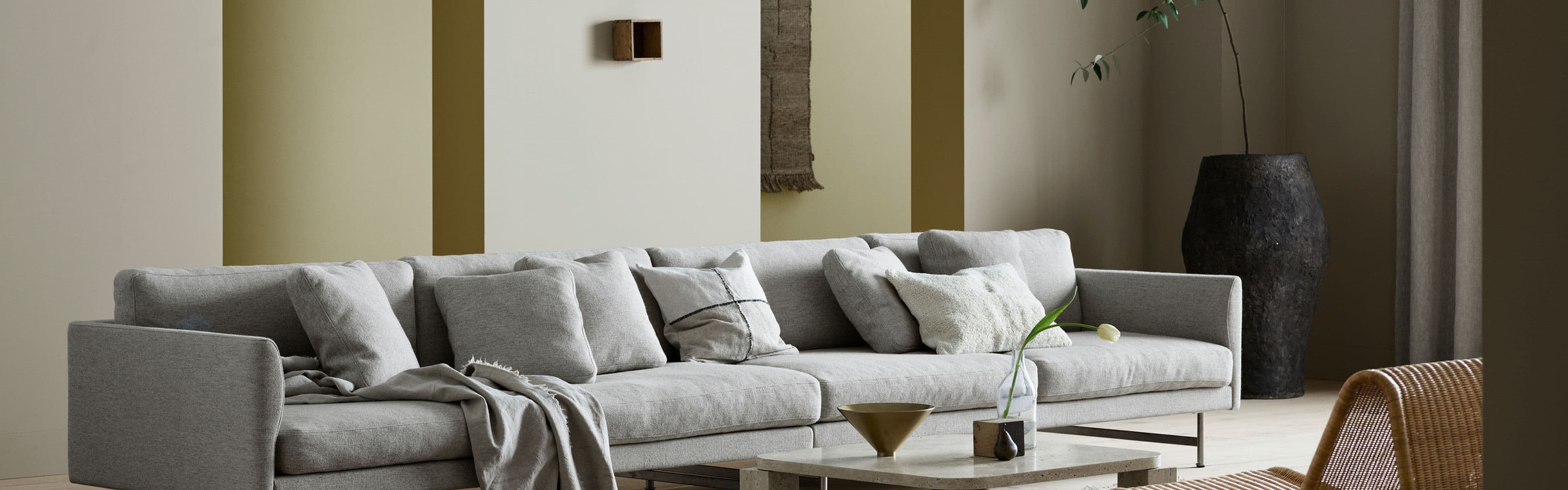 Stue med stor sofa og Jotuns nye trendfarger 12290 Antwerp Beige, 12075 Soothing Beige, 8583 Earthy Yellow og 0288 Mexico.