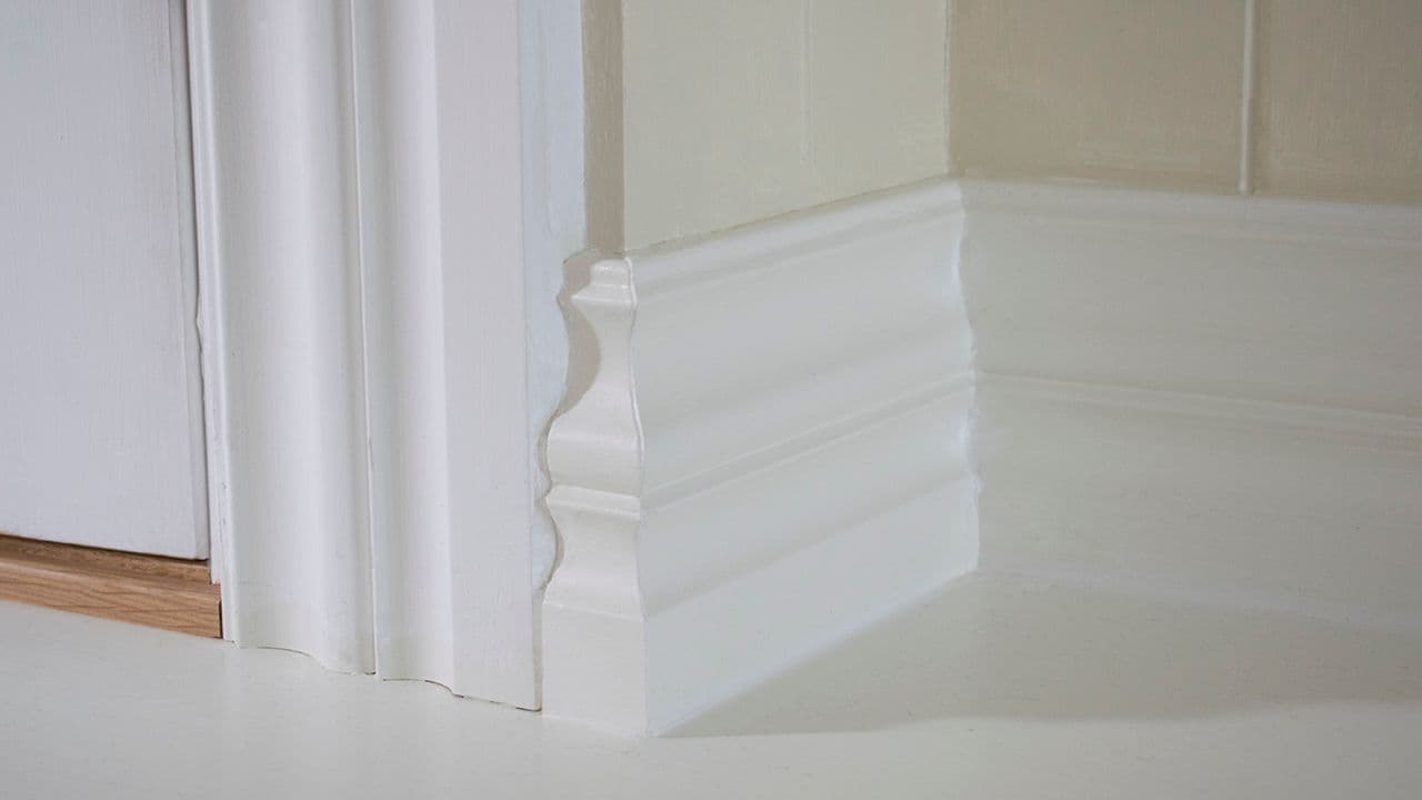 Brede lister med profil i hvitt til hvitt gulv.