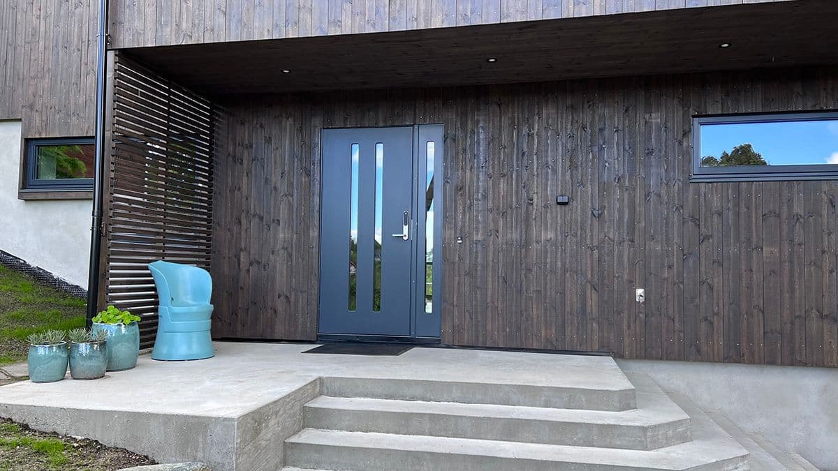 Nærbilde av et inngangsparti på et hus med en blå ytterdør.